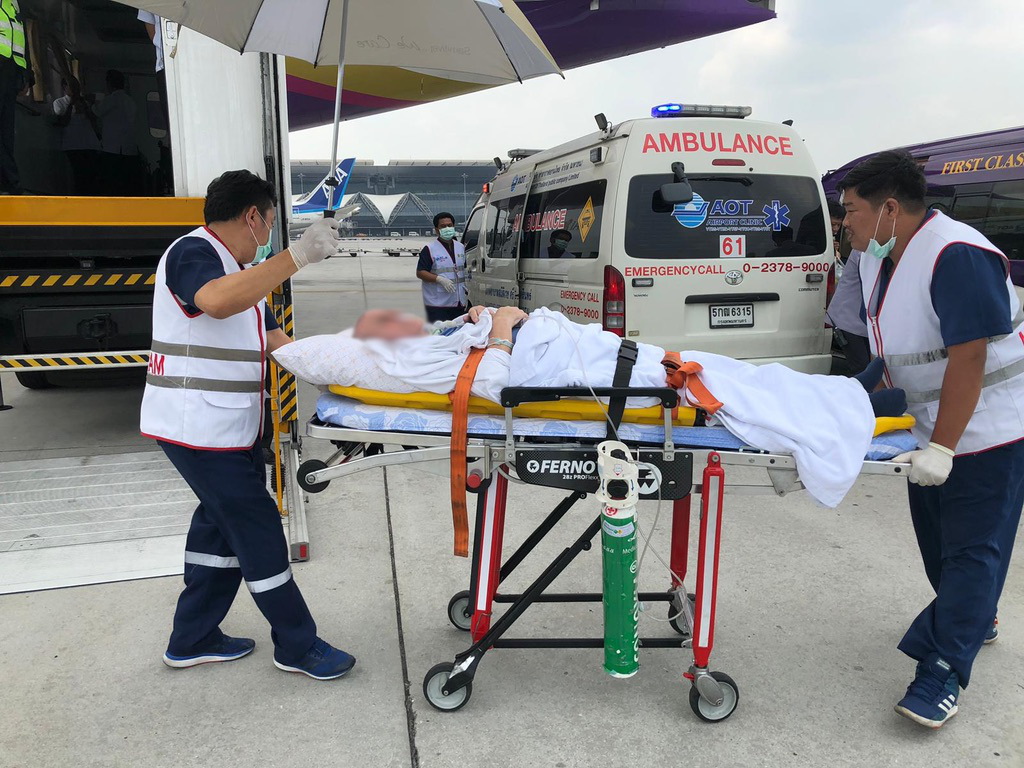Patient on stretcher being transferred to a plane