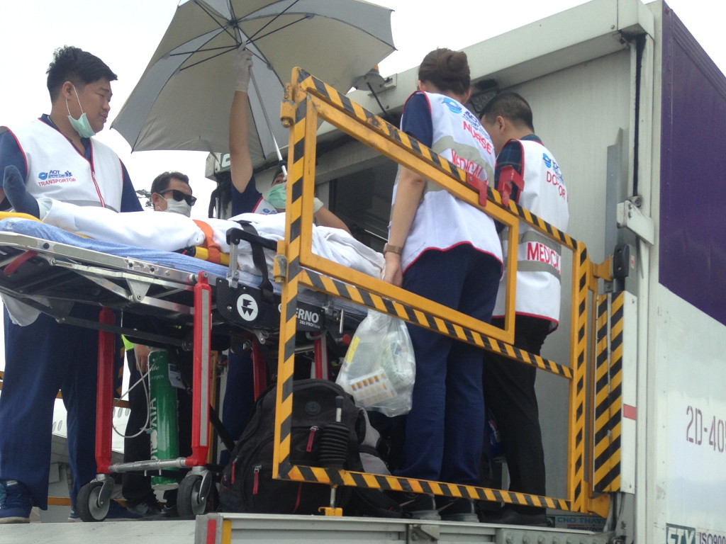 Stretcher patient being taken aboard an aircraft by a team of nurses and doctors